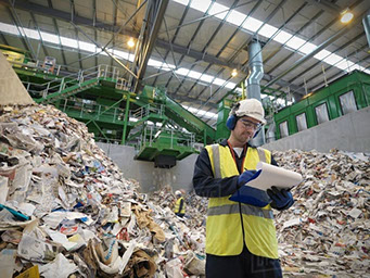 Picture of a worker performing a waste audit at a commercial recycling center